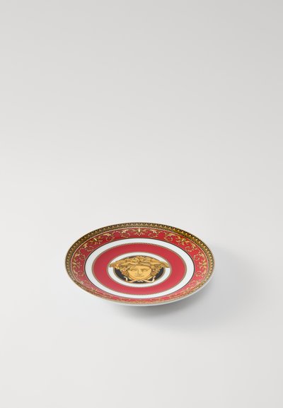 Στρογγυλό πορσελάνινο πιάτο με κόκκινο περίγραμμα και χρυσές λεπτομέρειες, κεντρικό χρυσό μοτίβο Μέδουσας και πολύπλοκα λουλουδένια σχέδια κατά μήκος της άκρης.