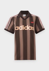 Καφέ ριγέ πόλο μπλουζάκι Adidas με V-λαιμόκοψη, μπορντό γιακά και κόκκινο λογότυπο. Διαθέτει λευκές και κόκκινες ρίγες στους ώμους, κοντά μανίκια.