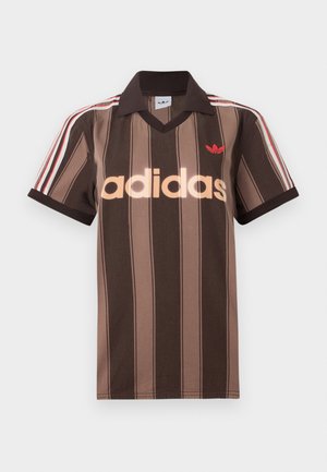 Polo Adidas a righe marroni con scollo a V, colletto bordeaux e logo rosso. Presenta strisce bianche e rosse sulle spalle, maniche corte.