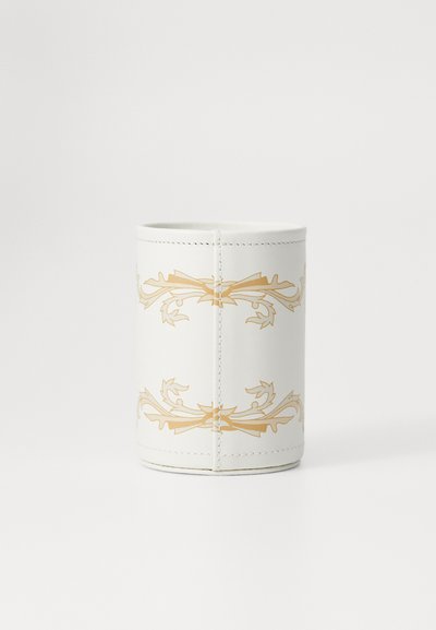 White cylindrical container made of leather-like material, featuring a gold floral design and visible stitching around the edge.