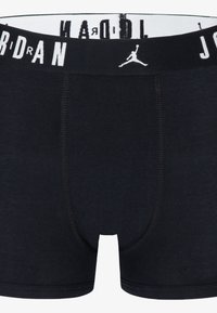 Črne bokserice iz mehkega materiala, z belim elastikom v pasu, na katerem je napisan tekst "JORDAN" in Jumpman logo.