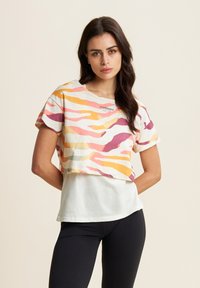T-shirt a maniche corte e taglio corto con un motivo ondulato colorato in rosa, arancio e giallo, con un pannello inferiore bianco e un logo sul petto.