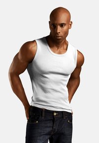 Weißes Baumwoll-Tanktop, figurbetontes Design, Rundhalsausschnitt, kombiniert mit dunkelblauen Jeans mit goldfarbener Hardware und Nähdetails.