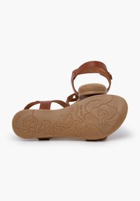 Sandal in pelle marrone con più cinturini, soletta imbottita e suola in gomma con motivo floreale. Design antiscivolo, made in Spain.