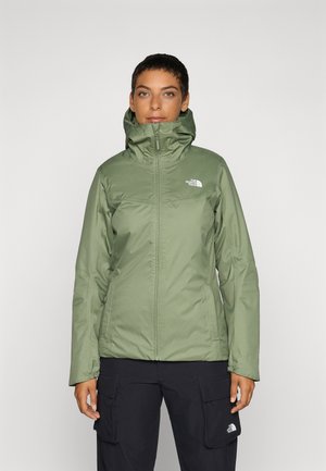 Veste imperméable verte, légère, avec un col haut et une fermeture éclair. Elle présente le logo North Face sur la poitrine et des poignets réglables.