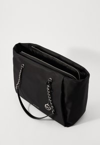 Borsa a tote in nylon nero con accenti in catena argentata, chiusura superiore con zip e doppi manici. Presenta un pendente con logo e una superficie texture.