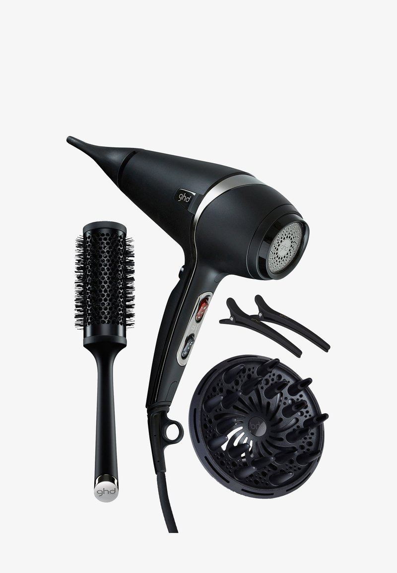 Zwarte föhn met afneembare diffuser, twee zwarte haarclips en een ronde geventileerde stylingborstel met haren op een witte achtergrond.