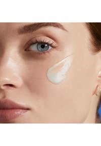 Crema idratante applicata sulla pelle, consistenza cremosa, finitura lucida, colore chiaro, che mette in risalto una pelle liscia e un aspetto naturale.