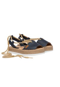 Sandalias de upper de tejido en color navy con puntera al aire, que cuentan con cintas en el tobillo, una suela intermedia envuelta en yute y una suela exterior de goma blanca para mayor agarre.