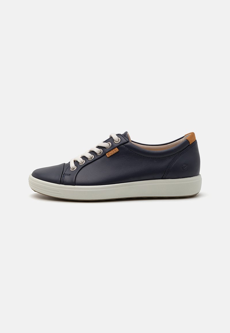 Navy blue leather sneaker with beige laces, white rubber sole, and a tan leather accent at the heel. Rounded toe and minimalist design.
