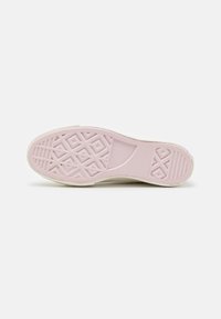 Rubber shoe sole with a textured pink surface, featuring a diamond pattern and embossed branding. Rounded edges and flat profile.
