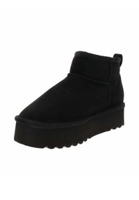 Botas de tobillo de ante negro con punta redonda, suela texturizada y caña corta. Cuenta con una lengüeta para facilitar su puesta.