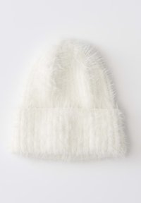 White fluffy knitted beanie hat with ribbed fold-over cuff on a plain light background.