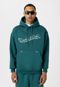 Turquoise hoodie met logo, trekkoord en voorzak. Zacht materiaal, relaxte pasvorm, ribbelmanchetten en boord. Casual ontwerp met minimaal detail.
