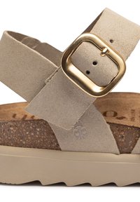 Tan suede strap sandal with a gold buckle, cork footbed, and light-colored rubber sole featuring a textured grip pattern.