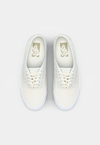 Witte sneakers met een gestructureerde bovenkant, uitgerust met een vetersluiting, padding rond de enkel en een rubberen zool. Vans-logo op de binnenzool.