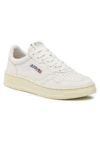 Sneaker bianco in pelle con profilo basso, punta tonda, dettagli perforati e suola in gomma color crema con accenti di branding sottili.