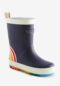Botte de pluie en caoutchouc, bleu marine avec des accents blancs, détail en couleurs arc-en-ciel sur le côté, semelle texturée et une languette multicolore à l'arrière.