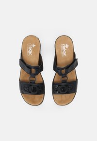 Sandali in pelle nera con cinturini regolabili, decorati con disegni a forma di cerchio, e una soletta imbottita color marrone chiaro per il massimo comfort.