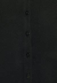 Černý kardigan z texturované pleteniny se šesti černými knoflíky na přední straně, který zdůrazňuje jednoduchý a funkční design.