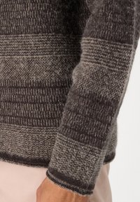 Pulover din lână cu un design texturat, tricotat în nuanțe de gri și brown, prezentând modele de dungi variate și manșete ribbrate.
