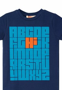 Marineblå T-shirt med et dristigt blåt gitterdesign, der har store bogstaver. Bogstavet "H" er fremhævet i orange. Blødt bomuldsstof.