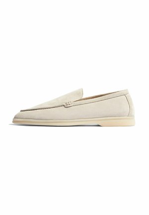 Beige ruskinds loafers med et elegant design, flad gummisål og en let stikdetalje på overdelen. Glat tekstur gennem hele skoen.