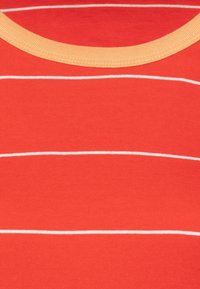 Rød bomulds T-shirt med hvide vandrette striber og en kontrasterende lys gul ribbet halsudskæring. Blød tekstur og afslappet design.