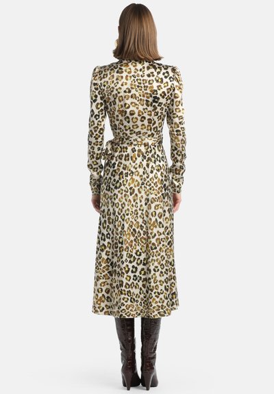 Leopardenmuster-Midikleid mit langen Ärmeln, tailliertem Schnitt, Satinmaterial und einem gebundenen Gürtelakzent. Trägt man mit knielangen, glänzenden bordeauxroten Stiefeln.