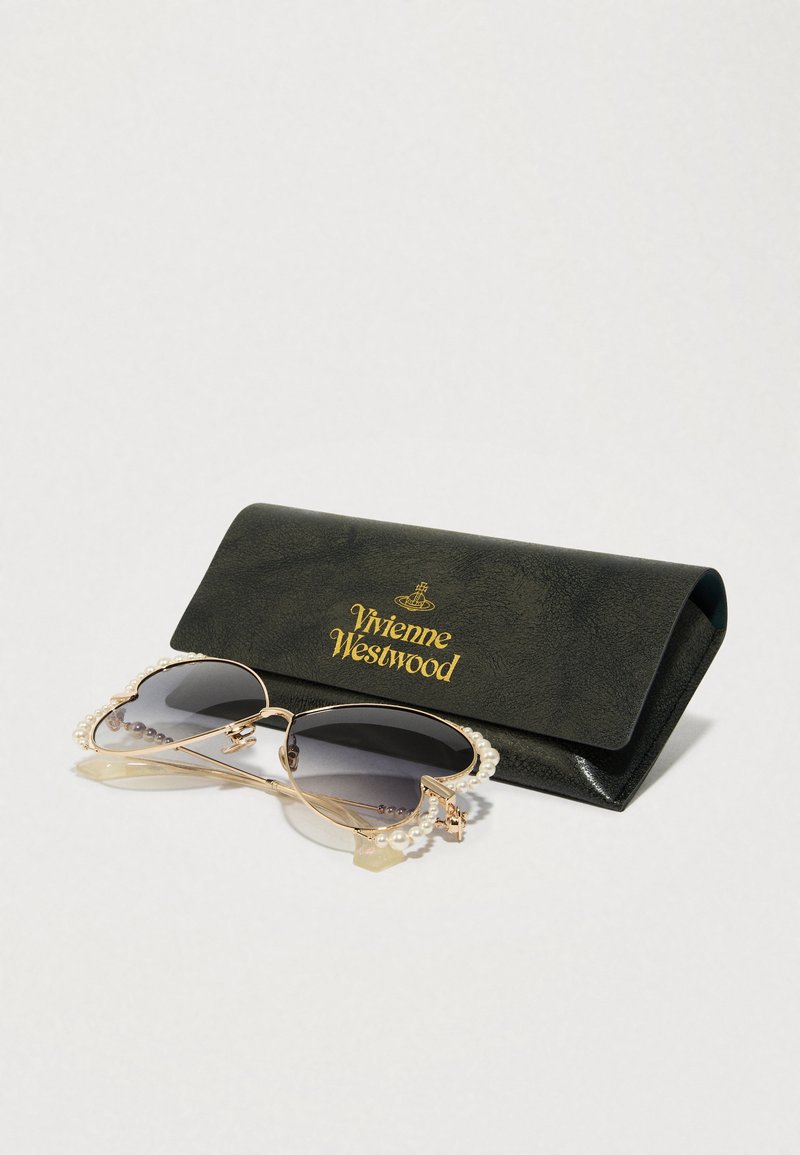 Lunettes de soleil avec des verres gris dégradés et une monture en métal doré, présentant des accents en perle sur les côtés, accompagnées d'un étui en cuir noir embossé du logo « Vivienne Westwood ».