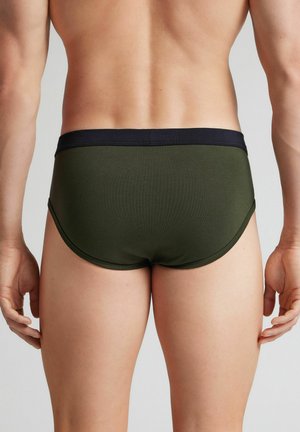 Herrenslip aus dunkelolivgrünem Stoff mit einem marineblauen Bund; verfügt über eine glatte Textur und eine konturierte Form für Komfort und Passform.