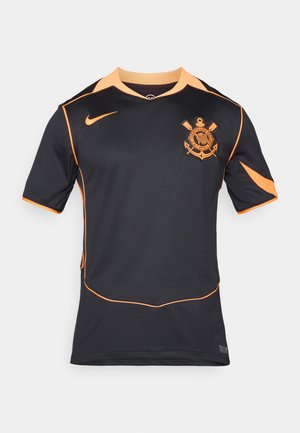 Sort atletisk skjorte med korte ærmer, der har orange detaljer og et logo på venstre bryst. Lavet af åndbart stof.