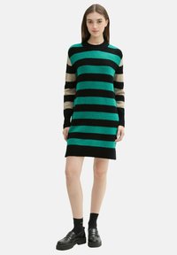 Dzianinowa sukienka swetrowa w poziome paski w kolorach turkusowym, czarnym i beżowym. Posiada okrągły dekolt oraz długie rękawy.