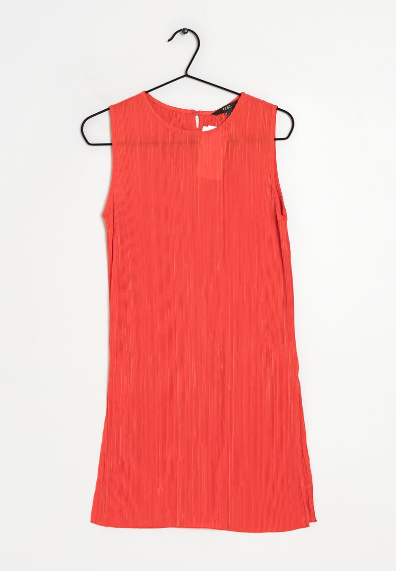 Robe sans manches rouge, texture plissée, encolure ronde, ouverture en forme de trou de serrure au dos, le tissu tombe légèrement, ourlet asymétrique. Accrochée à un crochet noir.