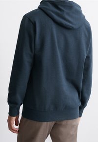 Mörkblå huvtröja i mjukt material, med dragsko i huvan, ribbade ärmslut och nederkant. Slät textur, minimal logotyp, avslappnad passform.