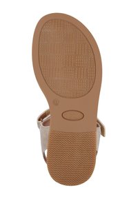 Flache Schuhsohle mit einer strukturierten braunen Gummibasis, die ein Diamanten- und Zickzackmuster aufweist, sowie einem beigen Stoffriemen an der Seite.