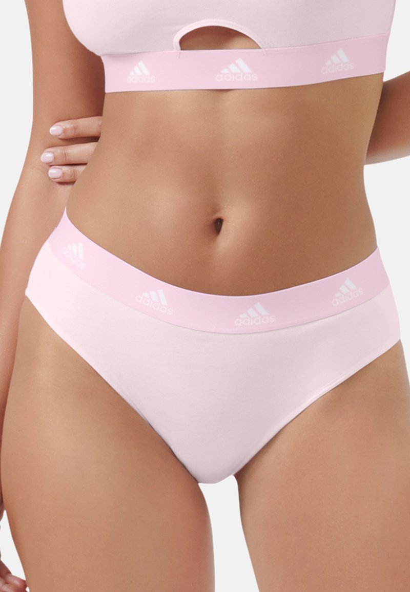 Sous-vêtements en coton rose clair avec une large ceinture arborant le logo Adidas blanc. Texture lisse et coupe classique slip.
