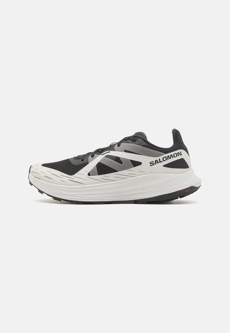 Scarpe sportive bianco e nere con tomaia in rete, tallone rinforzato e ammortizzazione leggera. Presentano strisce a contrasto e suola texturizzata.