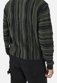 Strickpullover in Dunkelgrün und Schwarz, mit strukturierten vertikalen Streifen und gemusterten Details. Gerippte Bündchen und Saum.