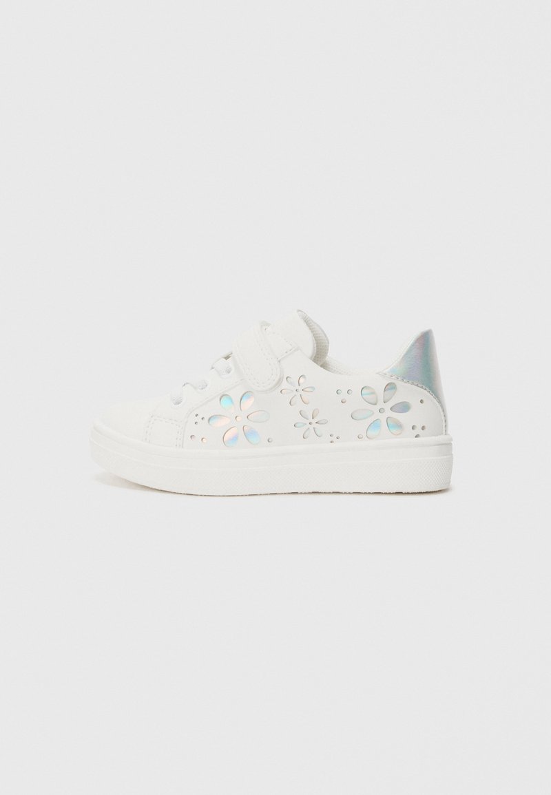 Vita sneakers med kardborreband, med utskurna blommönster, iriserande detaljer på hälen och en texturerad gummisåle.