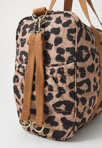 Borsa in stampa leopardata trapuntata, in tonalità beige e marrone, con manici a tracolla marroni e dettagli in metallo dorato. Texture liscia con una forma strutturata.