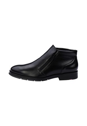 Black leather ankle boot with side zipper, smooth rounded toe, and low heel, shown from the outer side against a white background.