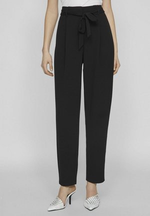Pantalon noir taille haute avec ceinture nouée, présentant un design structuré et des plis avant. Le matériau semble lisse et léger.