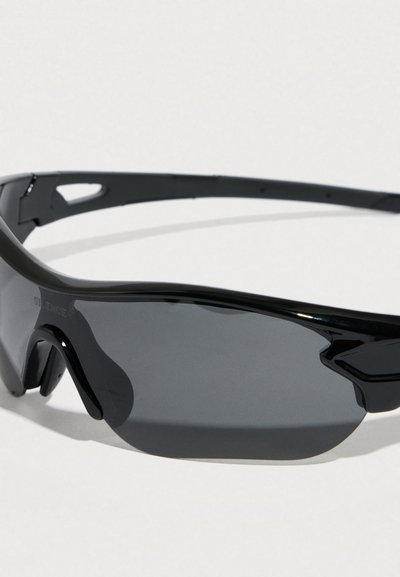 Μαύρα αθλητικά γυαλιά ηλίου τύπου wraparound με σκουρόχρωμους φακούς, ελαφρύ πλαίσιο και επενδυμένη γέφυρα μύτης σε ανοιχτό φόντο.