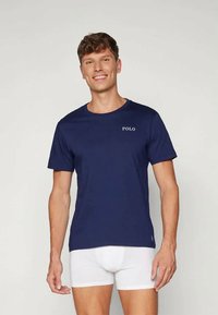 Μπλέ ναυτικού βαμβακερό T-shirt με κοντά μανίκια και στρογγυλή λαιμόκοψη. Διαθέτει λευκό λογότυπο "POLO" στο στήθος. Απλός, αναπνεύσιμους σχεδιασμός.