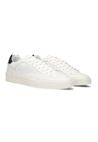 Witte leren sneakers met een gestructureerde afwerking, voorzien van een witte rubberen zool, vetersluiting en een marineblauw hielaccent.