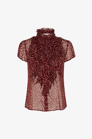 Blouse transparente bordeaux à manches courtes, col haut volanté et motif à pois ; présente un devant boutonné et un tissu texturé.