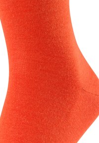 Kirkkaan oranssi sukka, joka on valmistettu sileästä, joustavasta kankaasta. Sukassa on saumaton varvasosa ja resorikuviointi mukavan istuvuuden takaamiseksi.