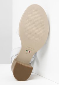 Sandale en cuir blanc avec un talon texturé marron et une semelle lisse beige. Marquée "NeroGiardini" et taille 37. Fabriquée en Italie.