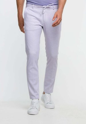 Light purple trousers made of a soft fabric, featuring a slim fit, drawstring waist, and paired with white sneakers.